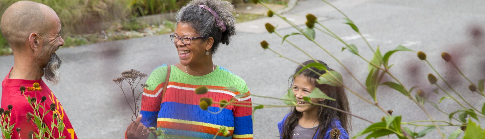 Parents and child laughing outside in the Outdoor Gardens