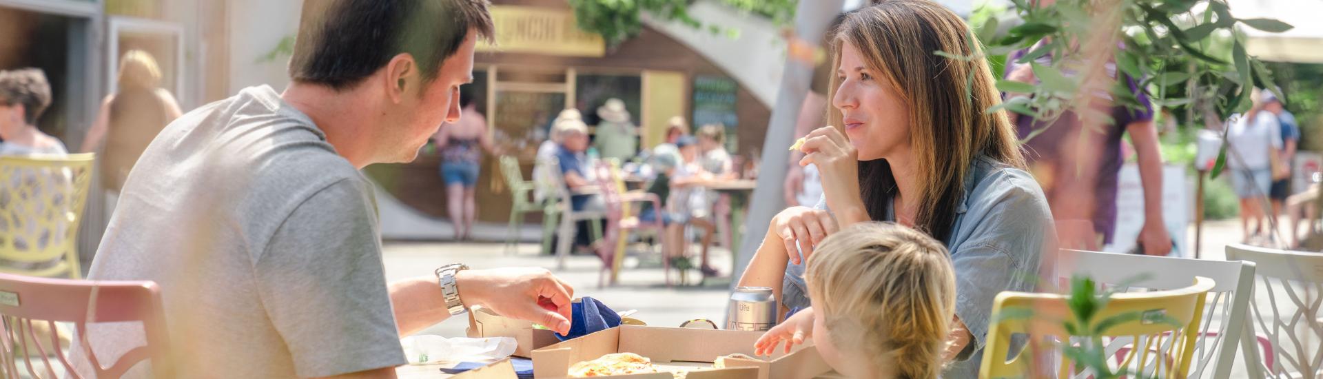 Family eating pizza in outside cafe