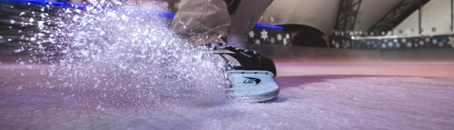 Up close shot of ice skates on ice rink