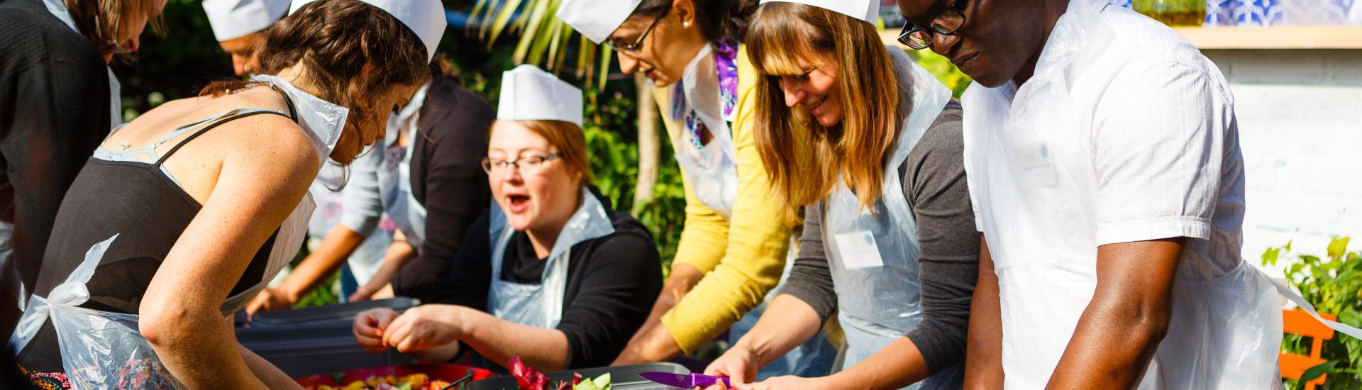 People preparing veg on an Eden Project Communities Camp