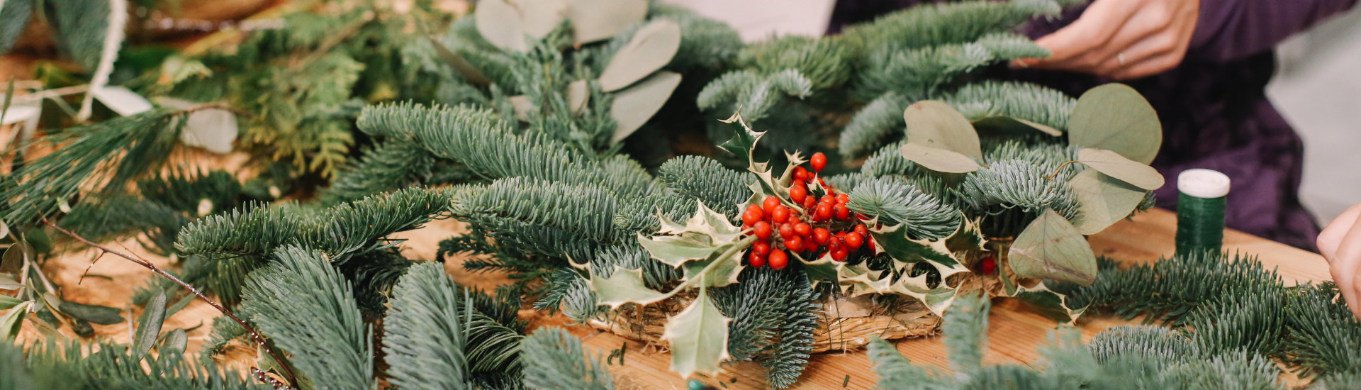 wreath making table with decorations and tools