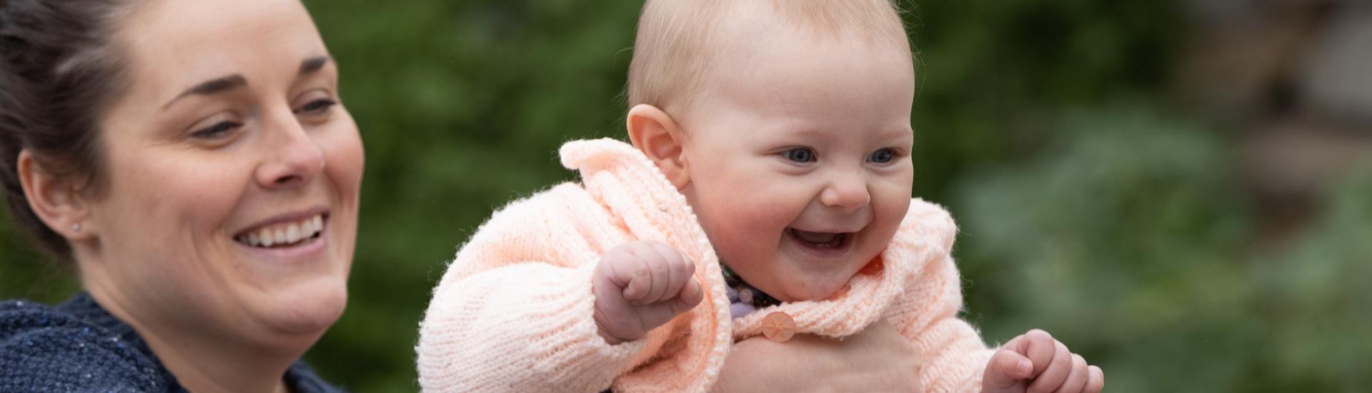 Mother holding smiling baby