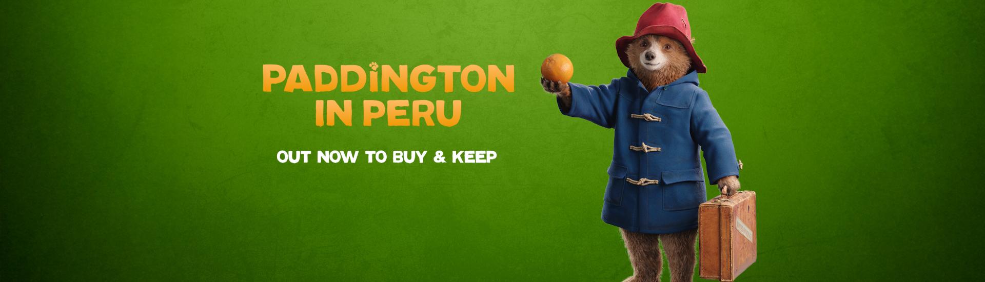 Paddington holding out an orange and carrying a suitcase