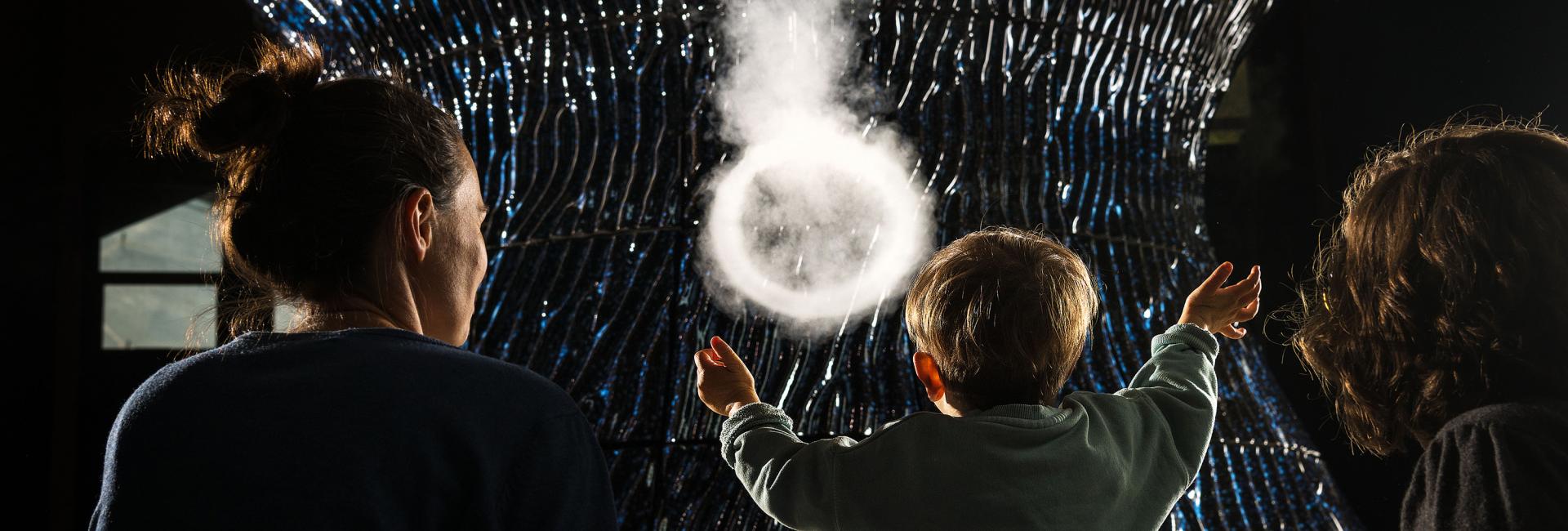 Child and couple interact with Infinity Blue sculpture